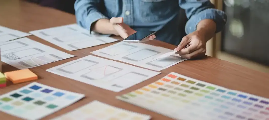A Square designer mapping out website wireframes alongside brand colour palettes